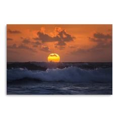 the sun is setting over the ocean with waves crashing in front of it and an orange sky