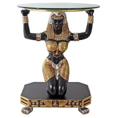 an egyptian figurine holding a glass table on it's head and legs