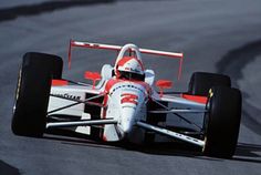 a man driving a race car on a track