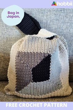 a crocheted bag sitting on top of a couch next to a blue and white pillow