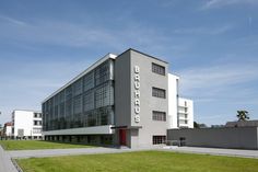 an office building on the corner of a grassy area in front of two other buildings