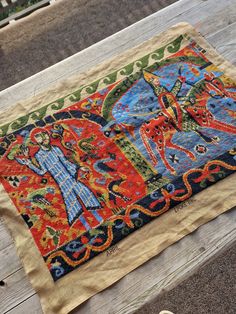 an old rug is sitting on a wooden bench