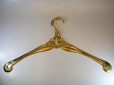 a gold coat hanger on a white wall