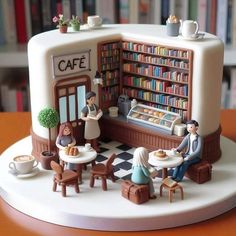 a cake with people sitting at tables in front of a coffee shop and bookshelf