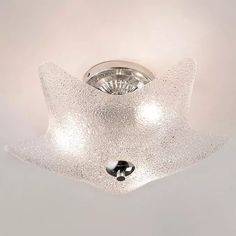 a ceiling light that is made out of glass and has a metal fixture in the middle