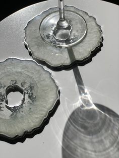 two glass dishes on top of a table with a wine glass in the middle and an upside down one