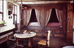 an old fashioned bedroom with wood paneling and drapes