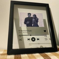 a black frame holds an image of a couple in love and the date on it