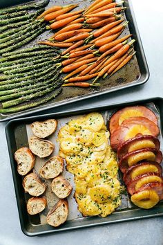 two trays filled with different types of food next to asparagus and carrots