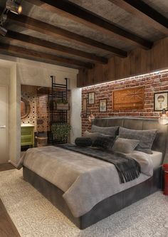 a large bed in a bedroom next to a brick wall and wooden flooring on the walls