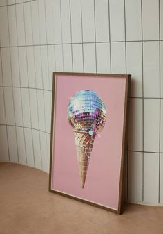 an ice cream cone is shown in front of a white tiled wall with pink and blue tiles