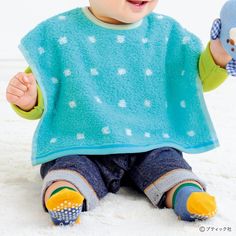 a baby sitting on the floor holding a stuffed animal