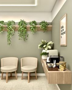 two white chairs sitting next to each other in a room with plants on the wall