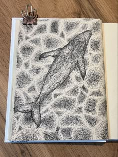 a notebook with a drawing of a dolphin on it