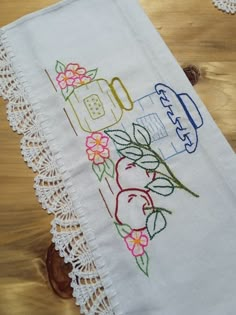 an embroidered tea towel on a wooden table