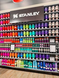 a display in a store filled with lots of different colored bottles and containers on the wall