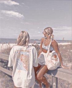 two women sitting on a bench looking out at the ocean and sand, with one holding a white bag