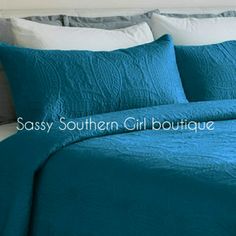 a bed with blue sheets and white pillows