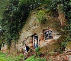 a man standing in front of a rock house