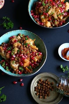 two bowls filled with food and garnished with parsley next to other dishes