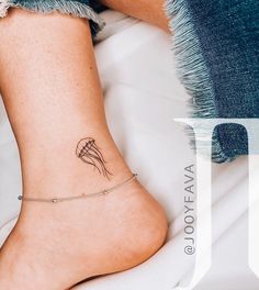 a woman's foot with a small tattoo on the side of her leg,