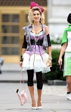 a woman walking down the street with a pink purse