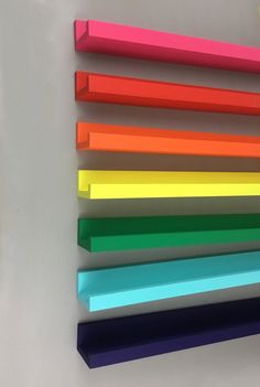 several different colored pencils are lined up on a white surface next to each other