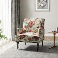 a living room with a flowered chair and table in front of the window,