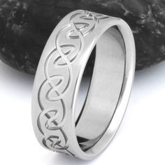 a wedding ring with the word love engraved on it and an intertwined design in silver