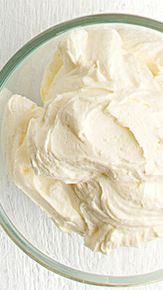 a bowl filled with white frosting sitting on top of a table