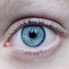 an eye with blue eyes is shown in this close up photo, the iris appears to be very large