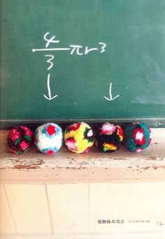 four colorful donuts are lined up in front of a blackboard with writing on it