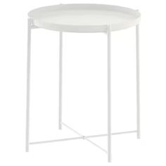 a white side table with metal legs and a round tray on the top that is holding a