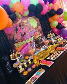 a table filled with lots of desserts and balloons