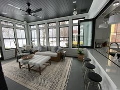 a living room filled with furniture and lots of windows