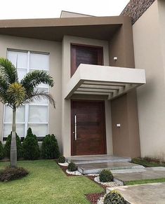 a modern house with palm trees in front of it and landscaping around the entrance area