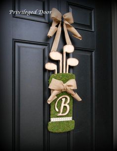 a door hanger with golf tees and the letter b hanging on it's front door