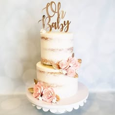 a three tiered cake with pink flowers and gold lettering that says baby on top