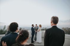 a bride and groom standing at the end of their wedding ceremony on top of a mountain