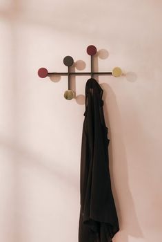 a coat rack with three coats hanging on it's sides and two jackets hanging from the hooks