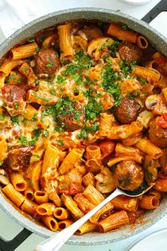 a skillet filled with pasta and meatballs