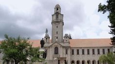 an old building with a clock tower in the middle of it's front yard