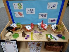 a wooden table topped with baskets filled with toys and paper cut outs on top of it