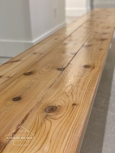 a wooden bench sitting in the middle of a room next to a wall and floor