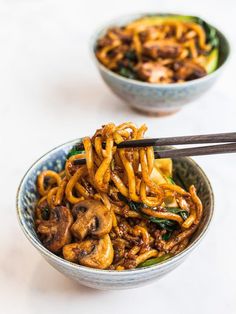 two bowls filled with noodles and mushrooms