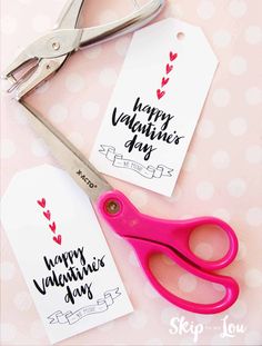 valentine's day gift tags and scissors on a pink polka dot tablecloth background