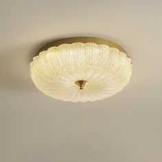 a ceiling light that is hanging from the ceiling in a room with beige walls and flooring