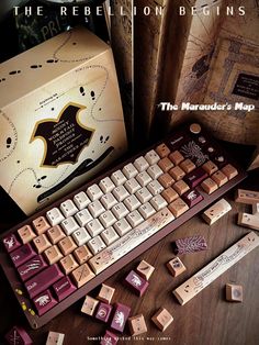 a computer keyboard sitting on top of a wooden table next to books and a box