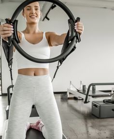 a woman is doing exercises with a hoop