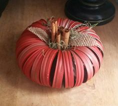 a red pumpkin sitting on top of a wooden table